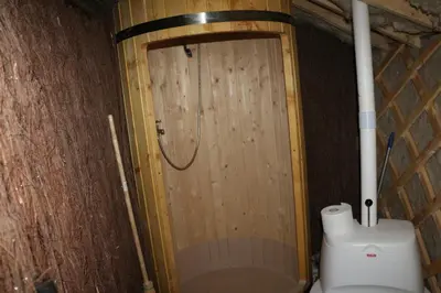 a bathroom with a toilet and a wooden door at Yurtos in Gaugariai