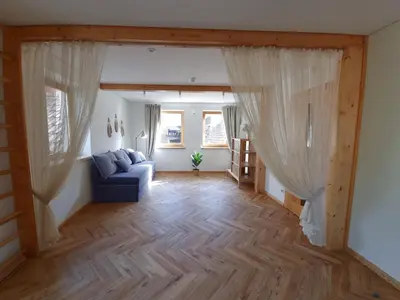 a living room with a blue couch and windows at Old Town Jiva apartment in Kaunas