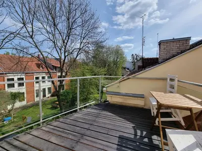 a balcony with a table and a wooden deck at Old Town Jiva apartment in Kaunas