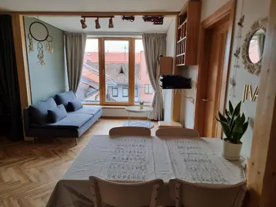 a living room with a table and a couch at Old Town Jiva apartment in Kaunas