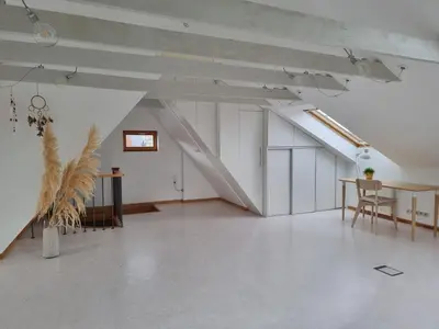 a large white room with a table and a staircase at Old Town Jiva apartment in Kaunas
