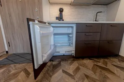 an empty refrigerator with its door open in a kitchen at LAISVĖ BOUTIQUE APARTMENTS in Kaunas