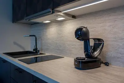a kitchen with a mixer on a counter next to a sink at LAISVĖ BOUTIQUE APARTMENTS in Kaunas