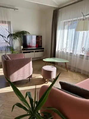 a living room with a couch and chairs and a tv at The Most Central Apartment in Kaunas