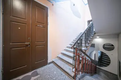 a stairway with a brown door and a staircase with a metal railing at Jasinskio Apartament - Lollo Stay in Vilnius
