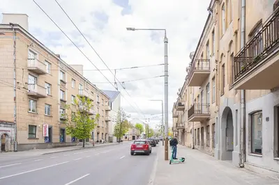a person on a skateboard on a city street at Jasinskio Apartament - Lollo Stay in Vilnius