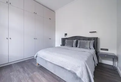 a bedroom with a large bed and white cabinets at Jasinskio Apartament - Lollo Stay in Vilnius