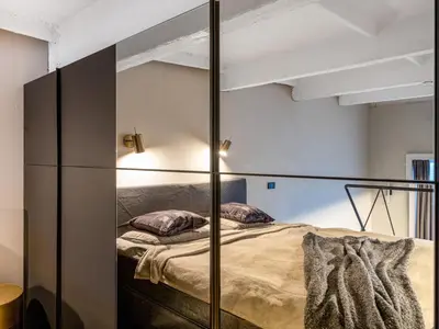a bedroom with a bed with a glass wall at Stylish Black and White loft in Kaunas