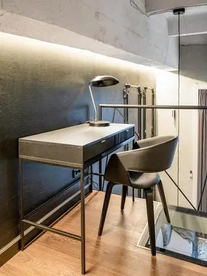a desk and a chair in a room at Stylish Black and White loft in Kaunas