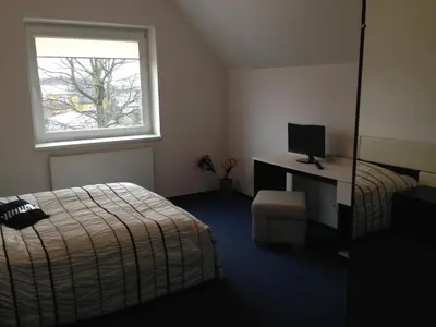 a bedroom with a bed and a desk with a computer at Luka in Marijampolė