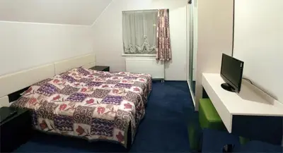 a bedroom with a bed and a desk with a computer at Luka in Marijampolė