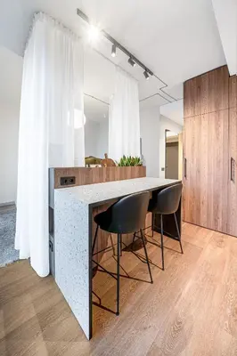 a kitchen with a large counter with two chairs around it at Cosy Panoramic Studio in the center for 1-2 pers. in Kaunas