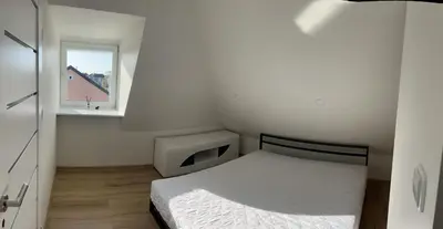 a small bedroom with a bed and a window at Centro apartamentai in Kalvarija