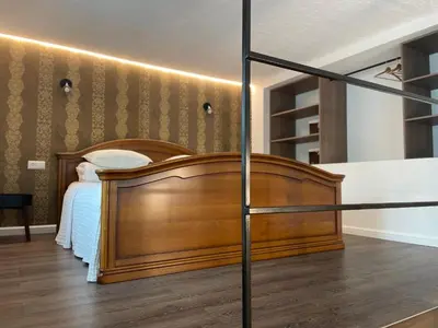 a bedroom with a large wooden bed and a staircase at Kęstučio 55 in Kaunas