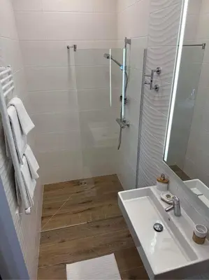 a white bathroom with a shower and a sink at Kęstučio 55 in Kaunas
