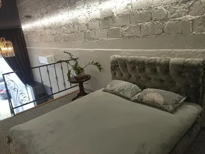 a bed in a room with a brick wall at Loftas in Druskininkai