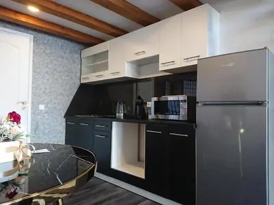 a kitchen with a stainless steel refrigerator and a table at Loftas in Druskininkai