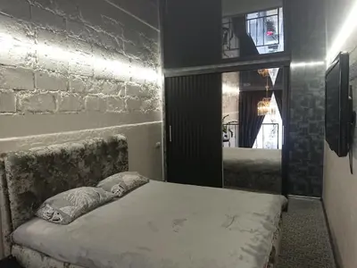 a bedroom with a bed and a brick wall at Loftas in Druskininkai