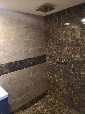 a bathroom with a tiled shower with a sink at Loftas in Druskininkai