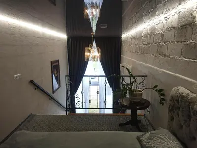 a room with a window with a table and a chandelier at Loftas in Druskininkai