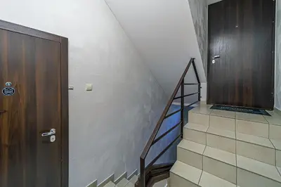 a staircase with a wooden door and a stair case at Grand Apt with air conditioning in Kaunas