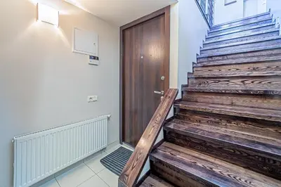 a wooden staircase with a wooden door in a room at Grand Apt with air conditioning in Kaunas