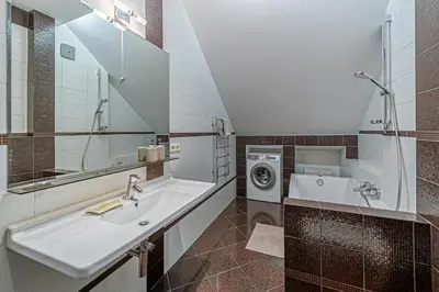 a bathroom with a sink and a washing machine at Grand Apt with air conditioning in Kaunas