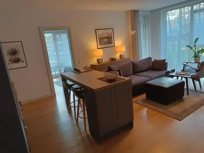 a living room with a couch and a table at Moderniškas ir jaukus butas gamtos apsuptyje in Druskininkai