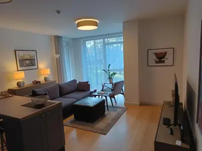 a living room with a couch and a table at Moderniškas ir jaukus butas gamtos apsuptyje in Druskininkai