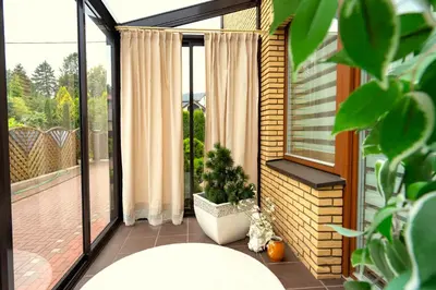 a balcony with a large window with a potted plant at Cozy house in Vilnius in Vilnius