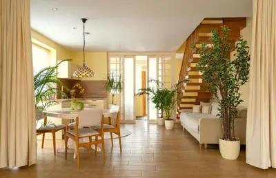 a living room with a table and chairs and plants at Cozy house in Vilnius in Vilnius