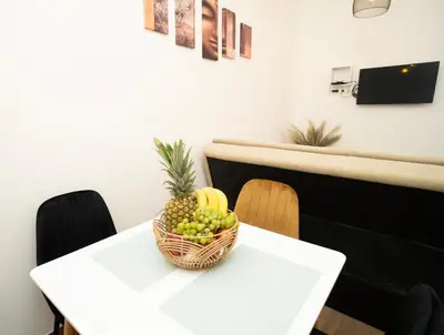 a basket of fruit on a white table at Downhill Apartment with a Private Terrace in Kaunas