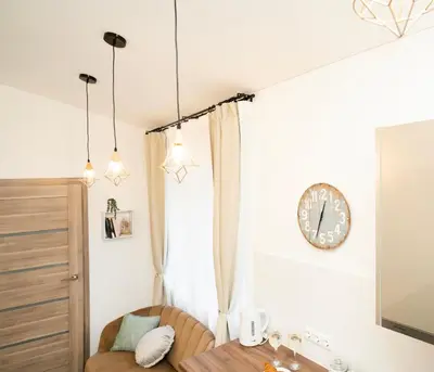 a room with a table and a clock on the wall at Downhill Apartment with a Private Terrace in Kaunas