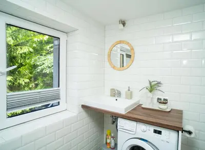 a bathroom with a sink and a washing machine at Downhill Apartment with a Private Terrace in Kaunas