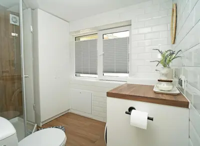 a white bathroom with a toilet and a window at Downhill Apartment with a Private Terrace in Kaunas