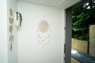 a white wall with a dream catcher hanging on it at Downhill Apartment with a Private Terrace in Kaunas