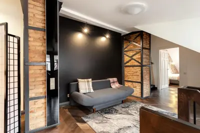 a living room with a couch and a black wall at 3 Bedroom Duplex Apartment next to the Gates of Dawn in Vilnius