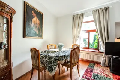a dining room with a table and chairs and a window at Classic Old Town Apartment next to the Gates of Dawn in Vilnius