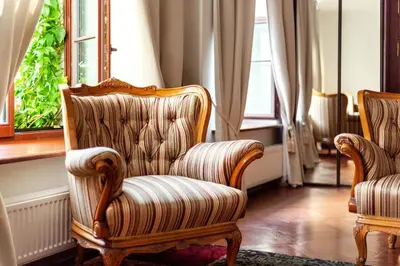 a living room with two chairs and a window at Classic Old Town Apartment next to the Gates of Dawn in Vilnius
