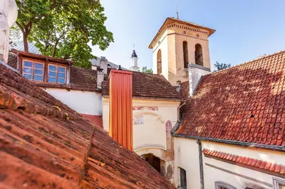 a group of roofs with a church in the background at Classic Old Town Apartment next to the Gates of Dawn in Vilnius