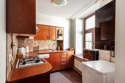 a kitchen with wooden cabinets and a stove top oven at Classic Old Town Apartment next to the Gates of Dawn in Vilnius