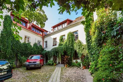 a house with a car parked in front of it at Classic Old Town Apartment next to the Gates of Dawn in Vilnius