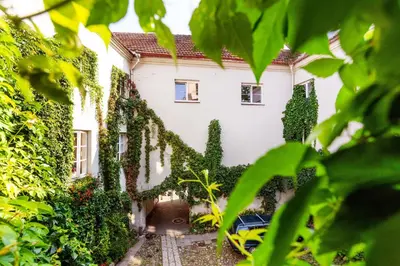 a house with ivy on the side of it at Classic Old Town Apartment next to the Gates of Dawn in Vilnius