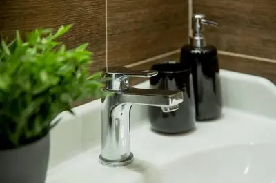 a bathroom sink with a faucet and a bottle of soap at Old Town Apartment in Vilnius