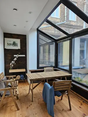 a room with a table and chairs and a large window at Cathedral apartment, perfect for couples in Vilnius