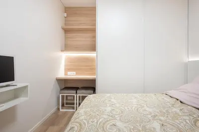a small bedroom with a bed and a television at Cathedral apartment, perfect for couples in Vilnius