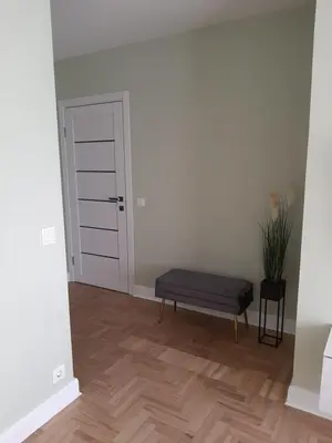 a empty room with a bench and a door at Visinskio apartamentai in Šiauliai