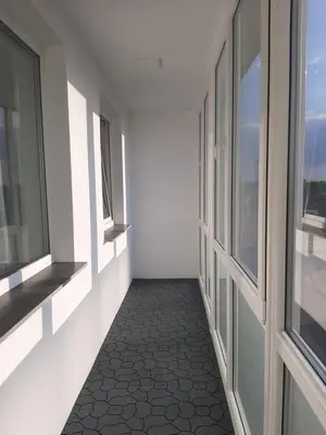 a hallway with windows and a tile floor at Visinskio apartamentai in Šiauliai