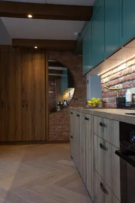 a kitchen with wooden cabinets and a brick wall at M8 Exclusive Studio Apartment in Kaunas