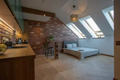 a room with a bed and a kitchen with skylights at M8 Exclusive Studio Apartment in Kaunas